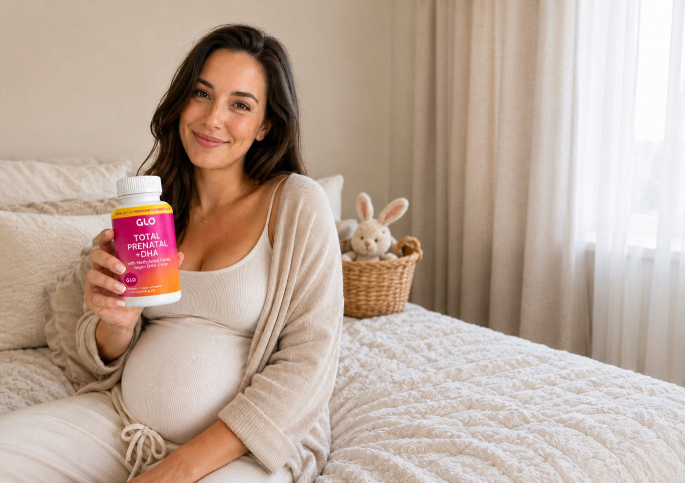 A pregnant mom at home holding GLO Total Prenatal + DHA