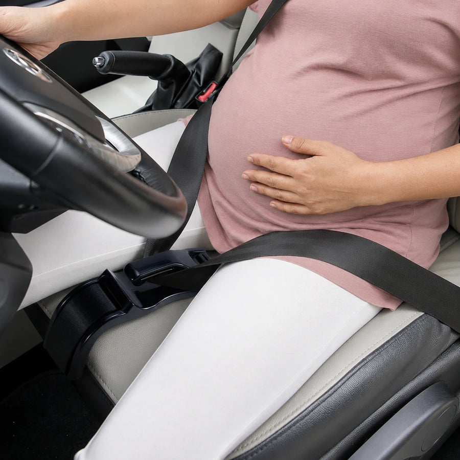 Close-up showing Mama Bub routing seatbelt safely below pregnant belly